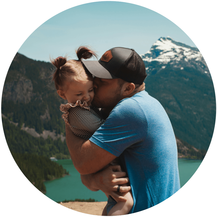 man kissing daughter in arms